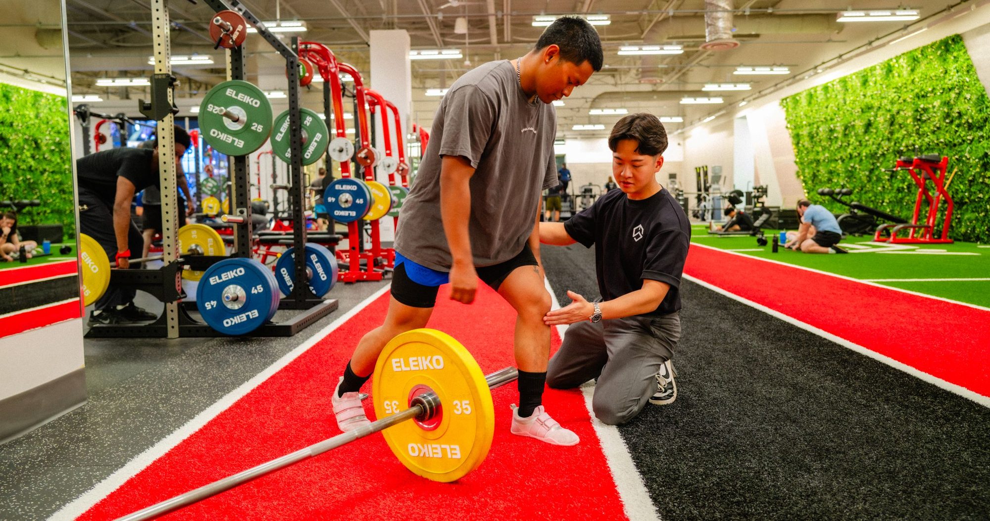 Garrett assessing a lifter's knee on the gym floor