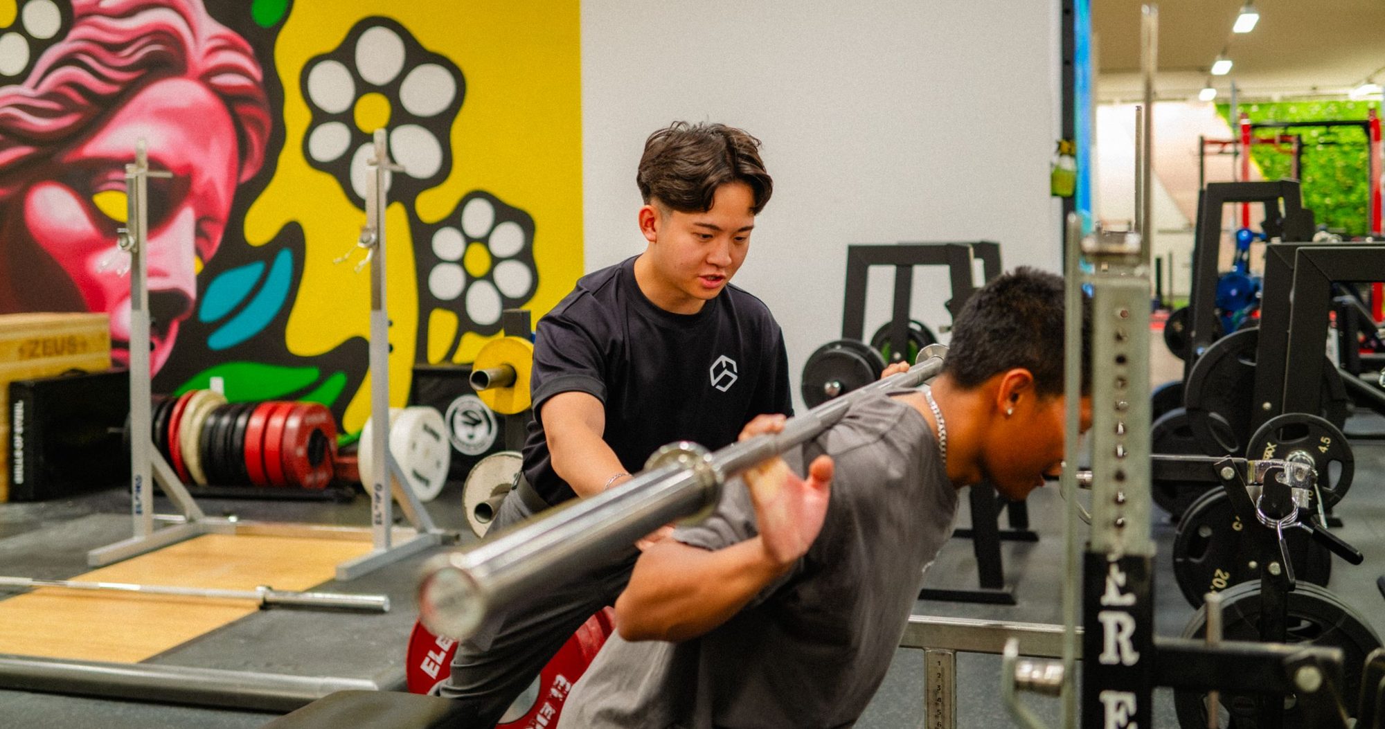 Garrett coaching a client through a squat